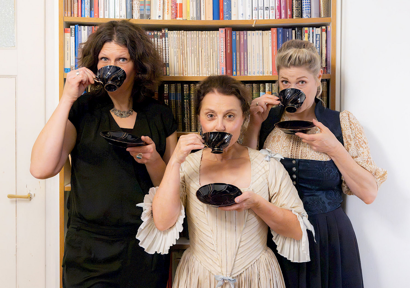 von li. nach re. sieht man Karin Füssel die Akkordeonistin, Gabi Altenbach als Christiana Mariana von Ziegler und Ines Honsel als Anna Magdalena Bach. Die Gesichter sind halb verdeckt da sie aus einer feinen Kaffeetasse trinken und über den Rand den Betrachter ansehen. Kaffee und heiße Schokolade waren zu Bachs Zeit DER letzte Schrei. :)