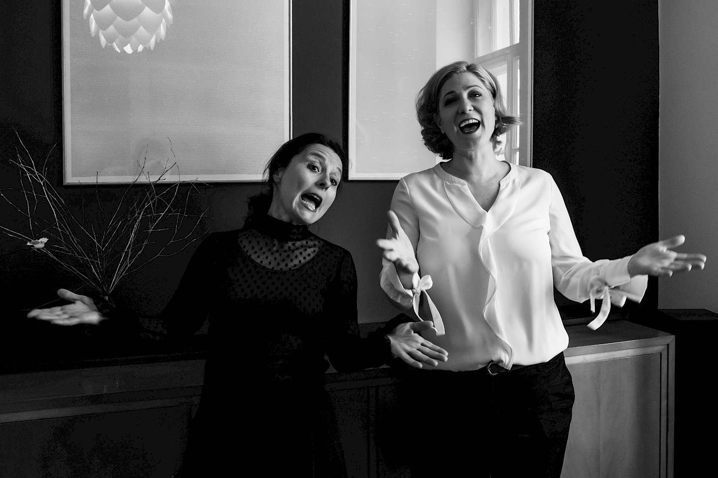 Gabi Altenbach und Ines Honsel stehen in einem Wohnzimmer und singen.